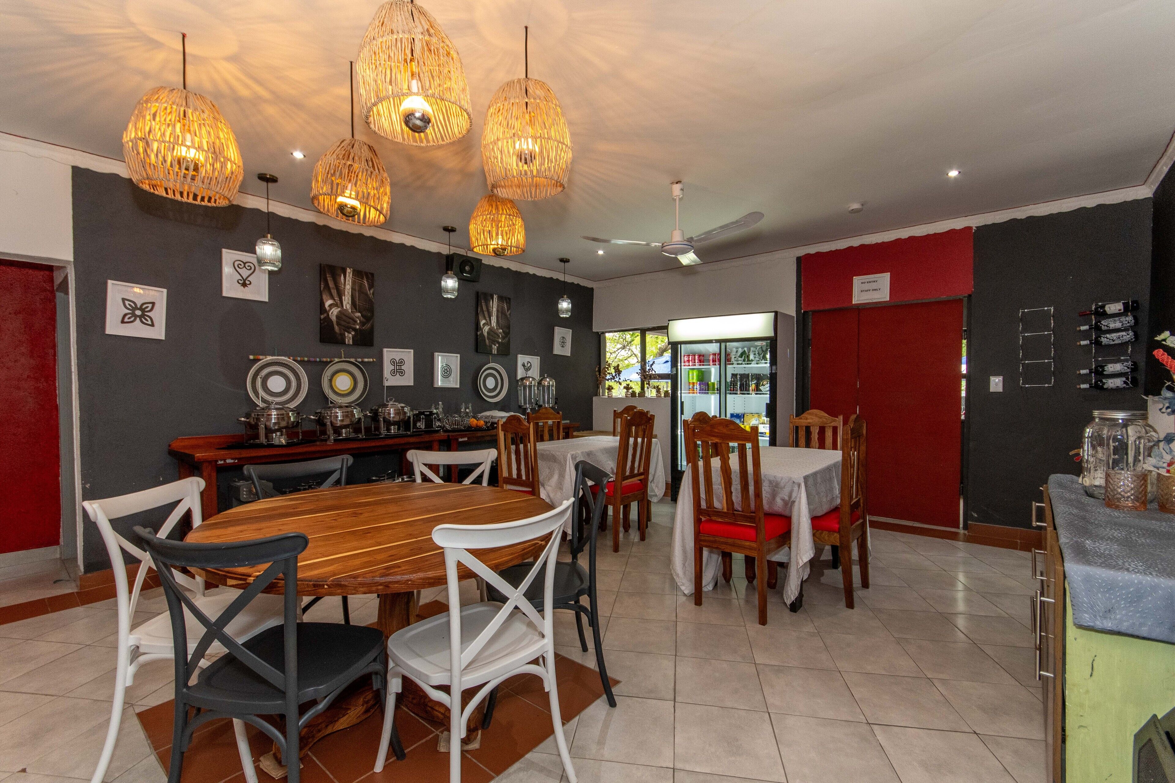 A dining area with a wooden table, chairs, and hanging wicker chandeliers.