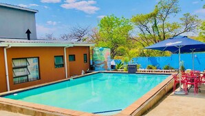 Una piscina con borde de azulejos, rodeada por una losa de concreto.