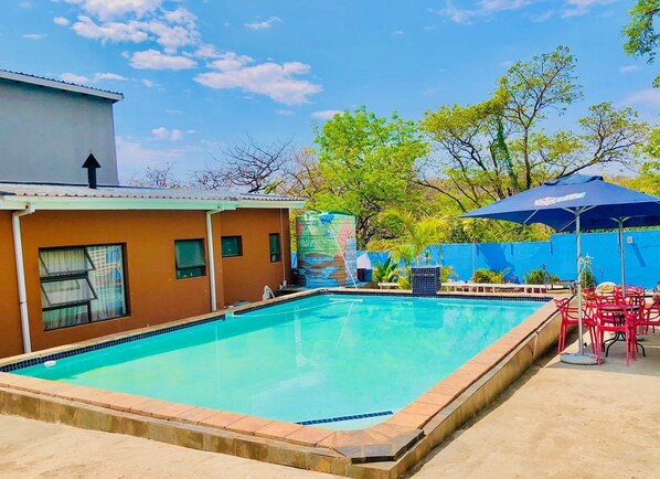 Una piscina con borde de azulejos, rodeada por una losa de concreto.