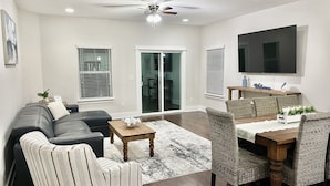 A living room with a sofa, chairs, a coffee table, and a dining area with a table and chairs. - Relax Near Beach, Shops, Parks, Mayo Clinic, Quick Drive to Downtown & Stadium (Jacksonville Beach)