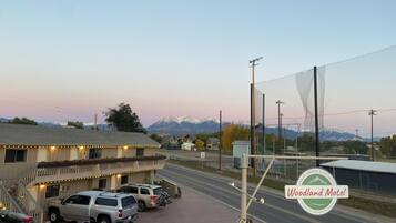 A motel with a parking lot, a mountain backdrop, and a sign indicating a speed limit of 35 mph.