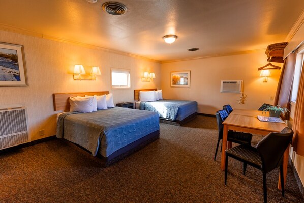 A hotel room with two beds, a dining table with chairs, and a small kitchenette area. - Woodland Motel (Salida)