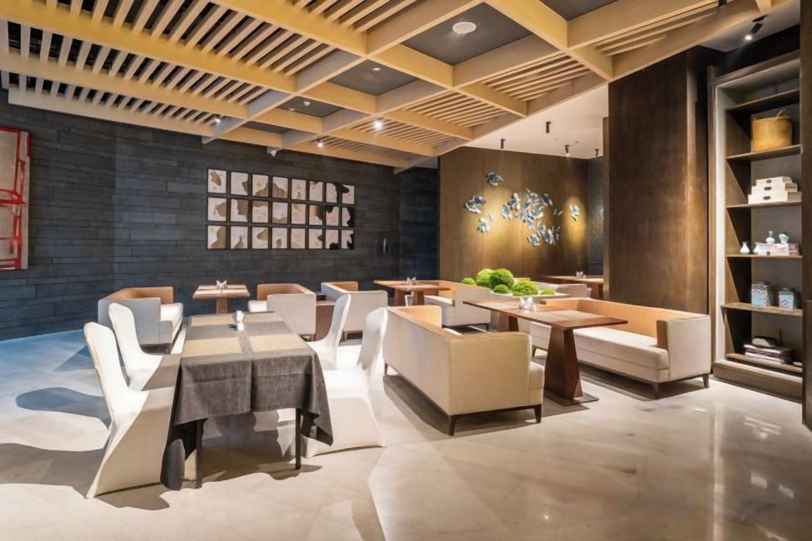 A modern interior with a dining area, seating arrangements, and a decorative wall.