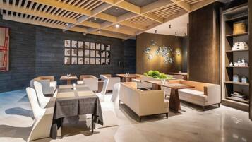 A modern interior with a dining area, seating arrangements, and a decorative wall.