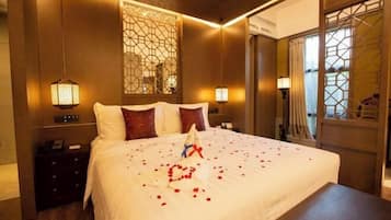 Una habitación de hotel con una cama grande, paneles decorativos en la pared y una mesita de noche con lámpara.