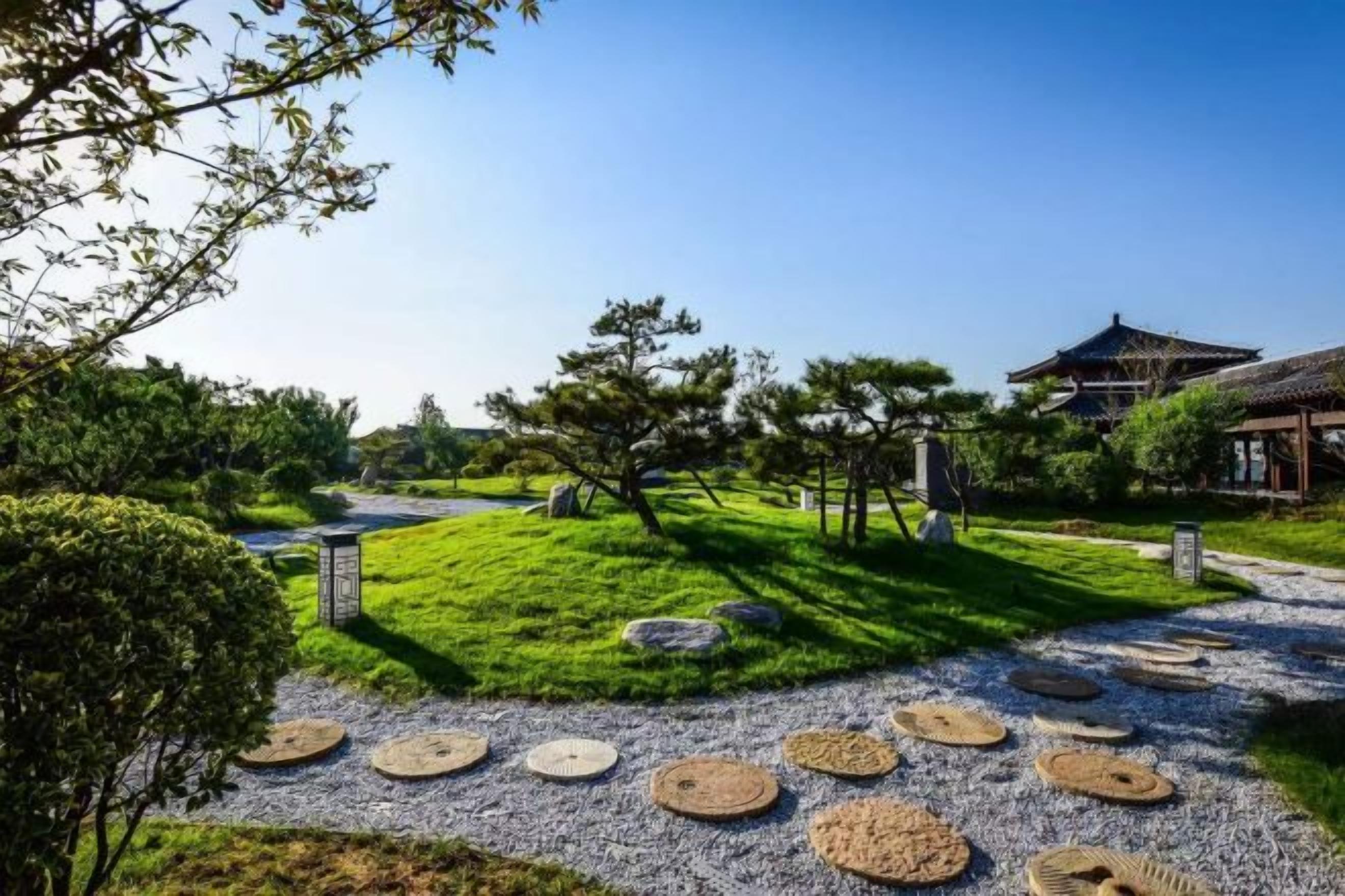 A traditional Japanese garden with a pathway, stone lanterns, and a pagoda.