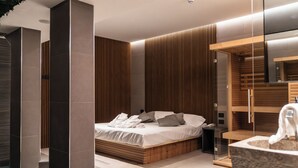 A modern bedroom with a bed, a wooden headboard, a bedside table, and a built-in bench. - Hotel Leonessa  (Brescia)