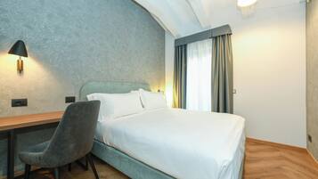 Een slaapkamer met een bed, een bureau en een stoel.