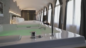 Ein modernes Badezimmer mit einer großen Badewanne, einer Duschkabine und einem Waschtisch mit Spiegel.