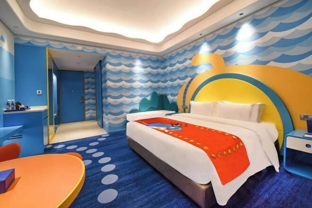 Una habitación de hotel moderna con una cama, un escritorio y una silla.
