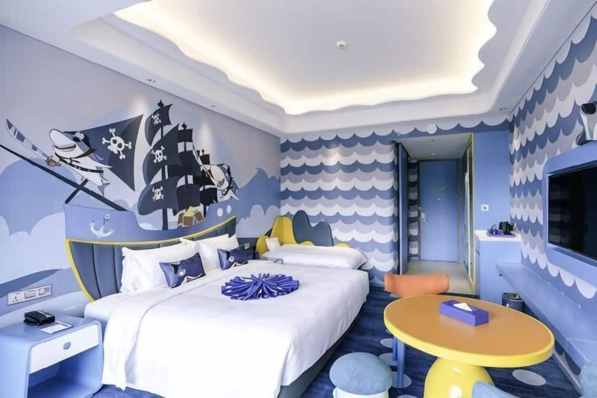 Un dormitorio con una cama, una mesita y un televisor.