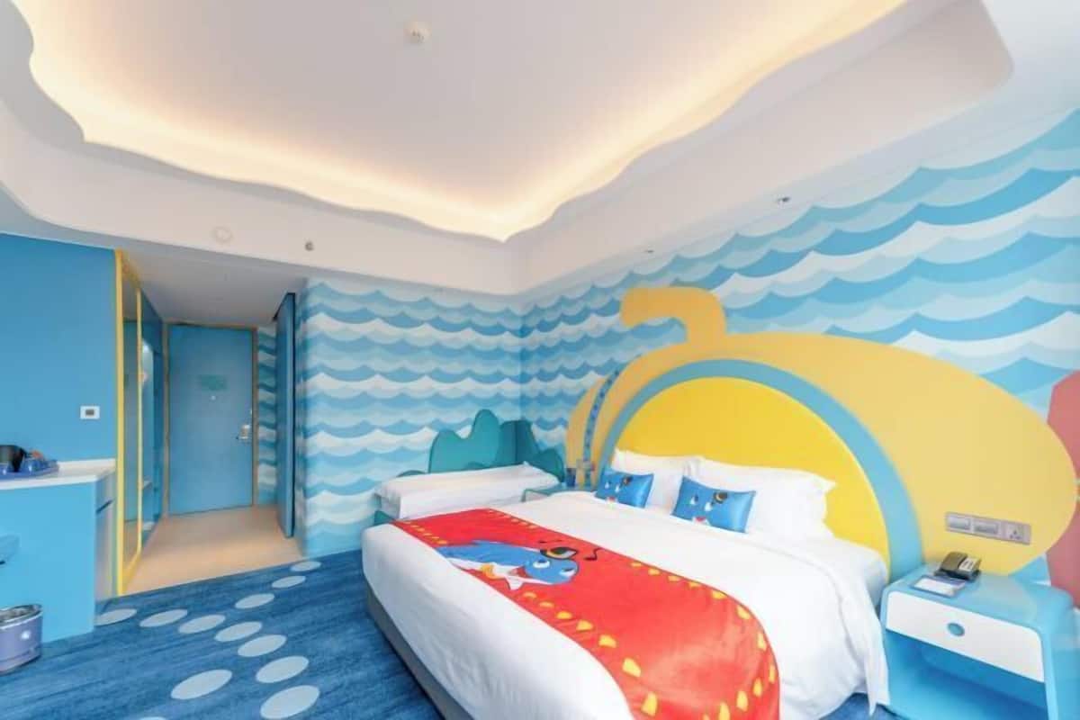 Un dormitorio con una cama, una mesita de noche y una pared con diseño de olas.