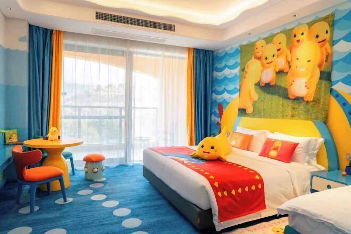 Una habitación de hotel con una cama, una mesita, una silla y una ventana con cortinas.