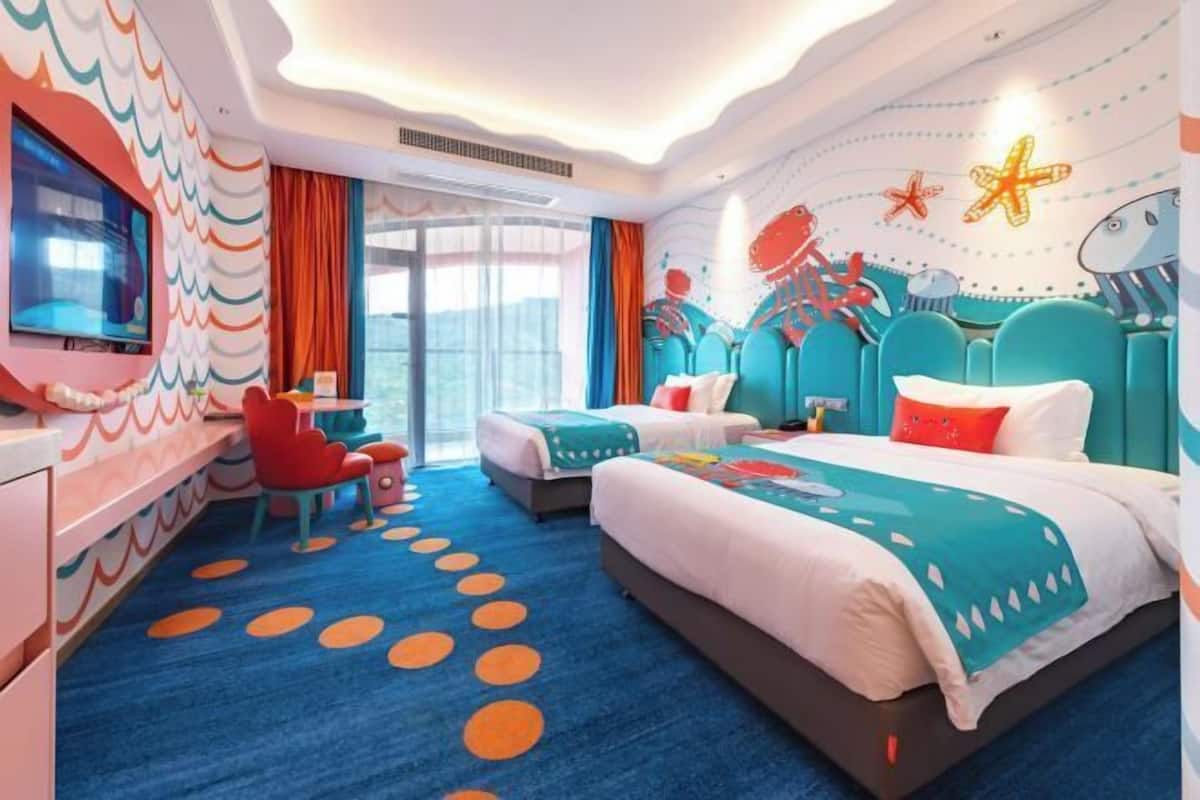Una habitación de hotel moderna con una cama grande, un escritorio y un televisor.