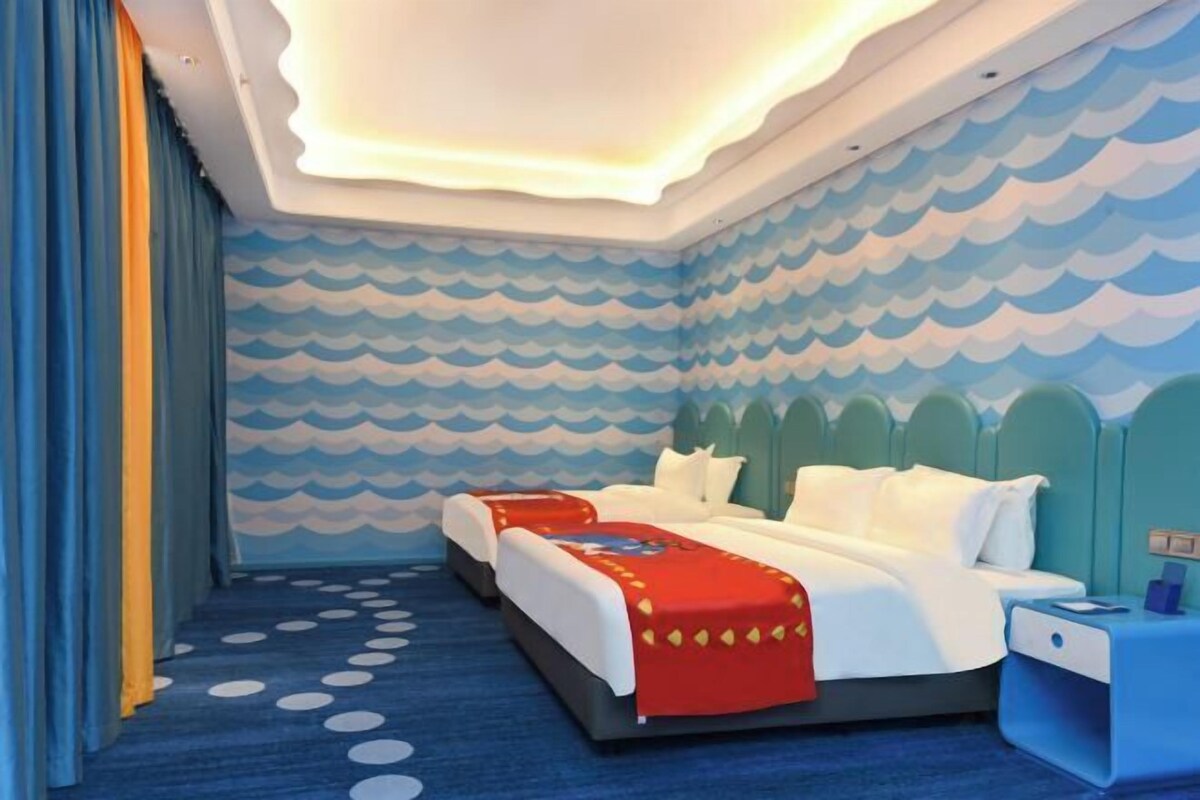 Una habitación con una cama, una mesita de noche y una pared con un diseño de olas.