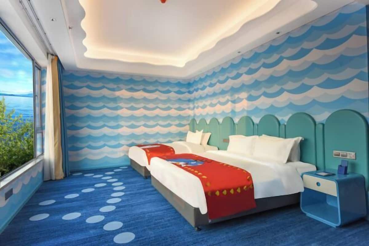 Una habitación con dos camas, vista al mar y suelo estampado.