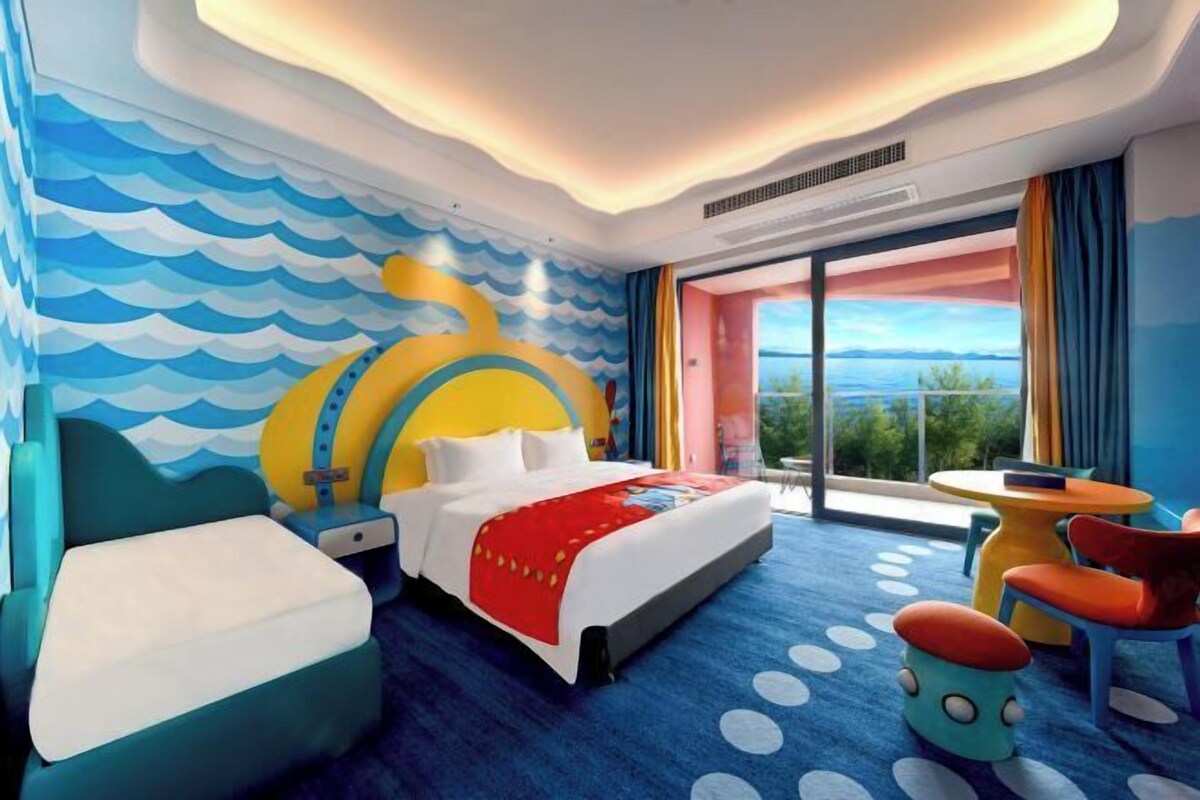 Habitación de hotel con una cama, un escritorio, una silla y vistas al exterior.