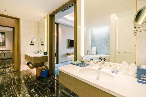 Un baño moderno con suelo de mármol, un espejo grande, un lavabo y tocador.