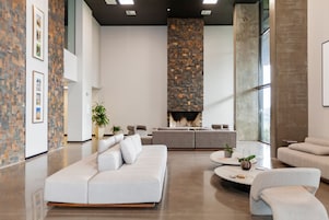 Uma sala de estar moderna com um amplo sofá seccional, uma lareira e design minimalista.
