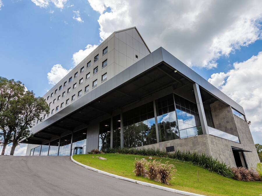 Un edificio moderno con techo plano, ventanas amplias y un lado inclinado.