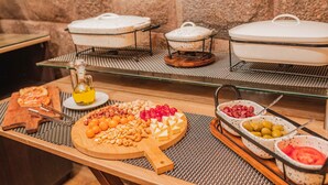 A buffet setup with various food items and containers. - ANAHUARQUE (Cusco)