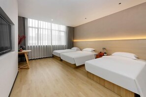Una habitación de hotel con un ventanal grande, un escritorio y dos camas.