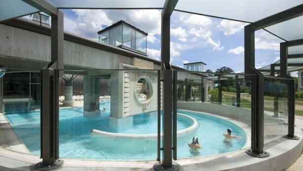 Ein moderner Pool mit einem gläsernen Bereich und einer spiralförmigen Wasserrutsche.