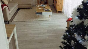 Ein Wohnzimmer mit einer Couch, einem Couchtisch und einem Weihnachtsbaum.
