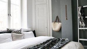 Un dormitorio con una cama, almohadas, un bolso colgado y un armario.