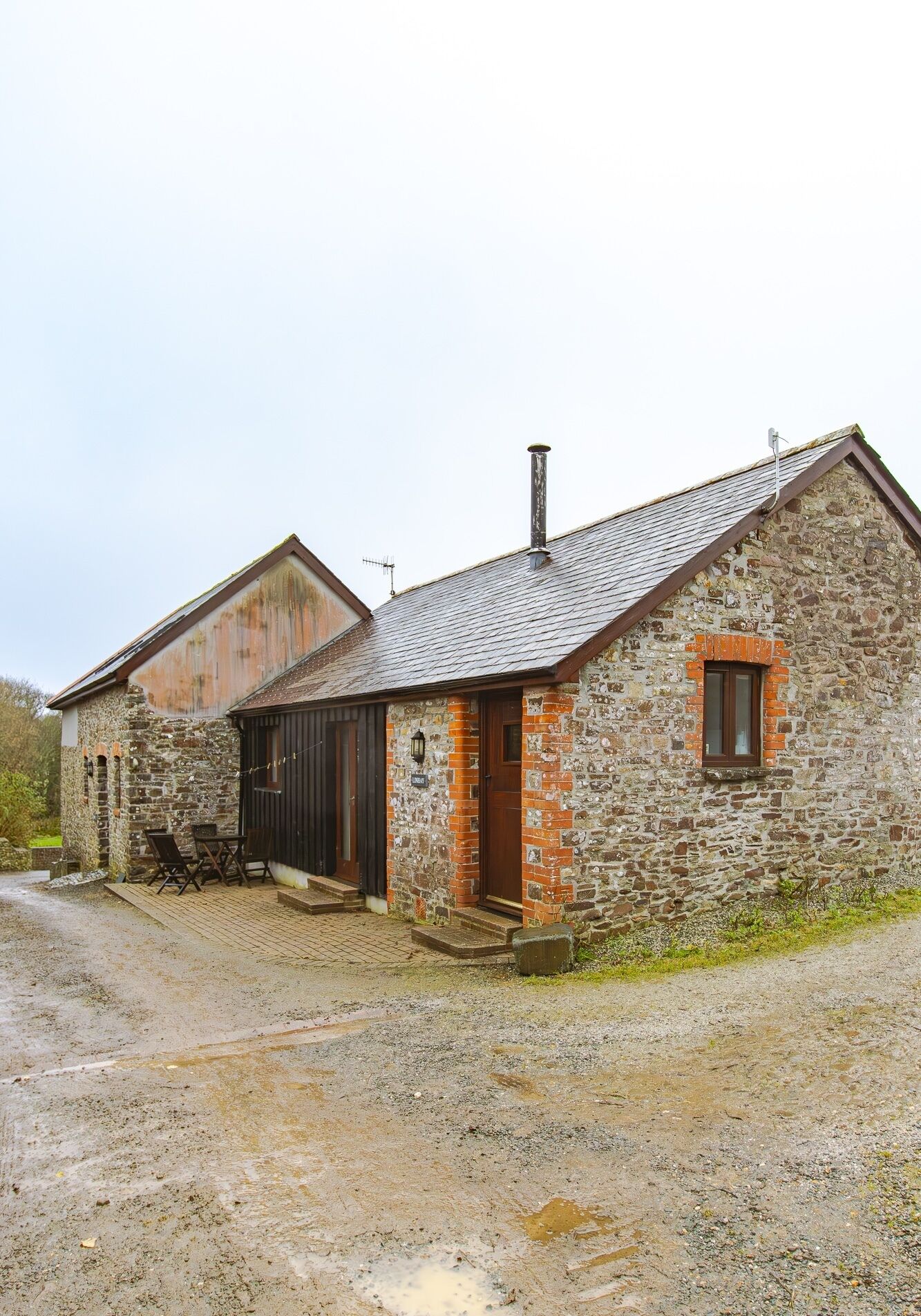 A stone building with a wooden door and a small window.