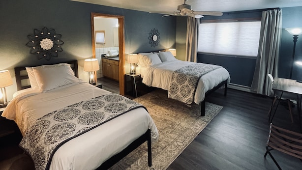 A hotel room with two beds, a ceiling fan, a large mirror, and a window with curtains. - Dune View -Star Gazing Getaway (Mosca)