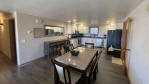 A spacious kitchen with modern appliances, a dining area with a marble table, and a small island. - Dune View -Star Gazing Getaway (Mosca)
