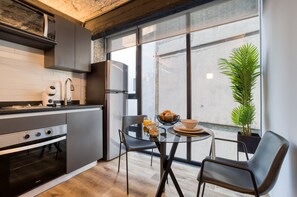 Industrial One-Bedroom Apartment | Cocina privada | Frigorífico grande, microondas, horno y placa de cocina