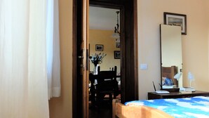 A bedroom with a wooden bed, a desk with a lamp, and a chair. - La Cheta - House in the hills with garden, between Lucca and the beaches of Viareggio (Orbicciano, Camaiore)