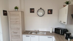 A compact kitchen with a sink, microwave, and cabinets.
