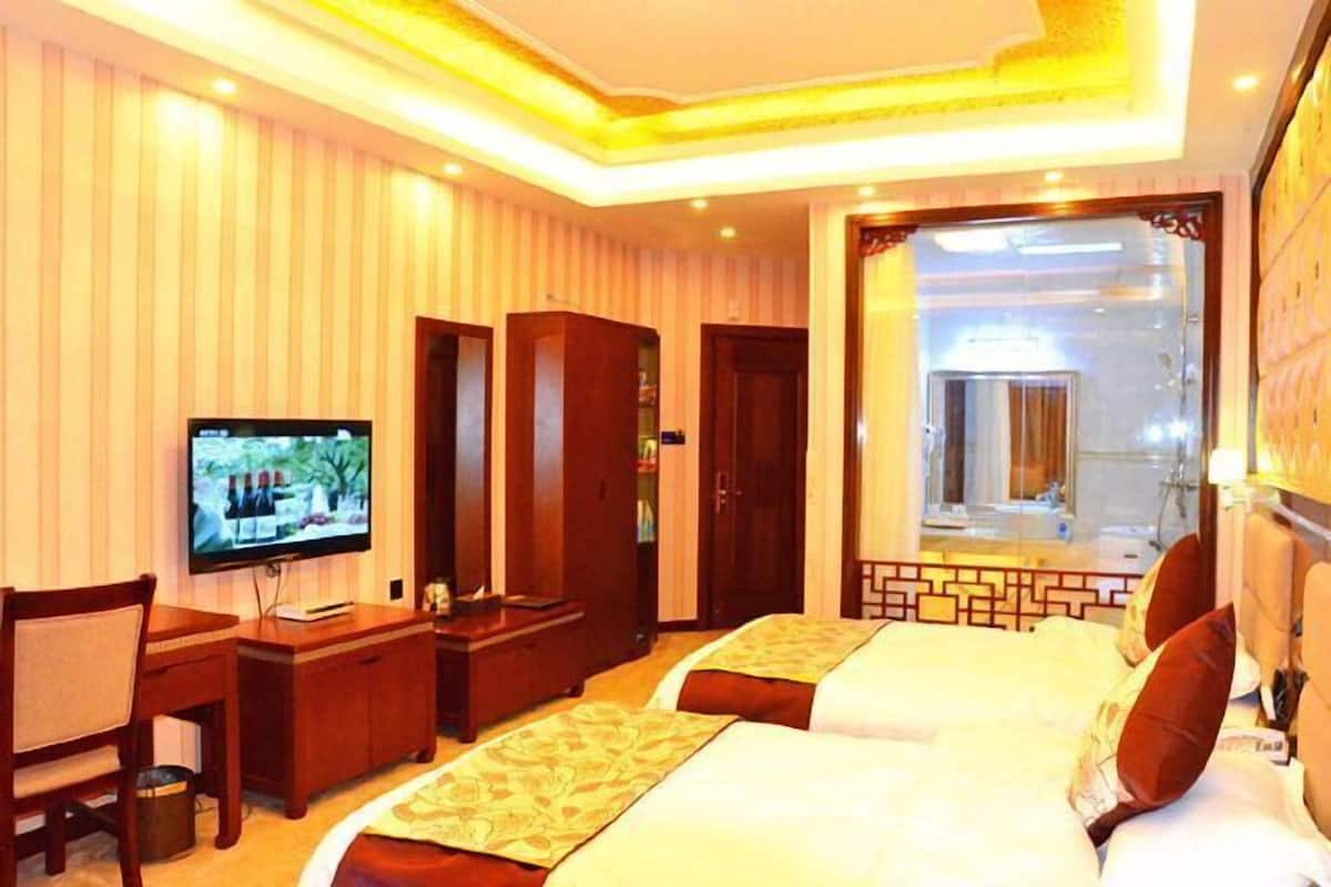 Enjoy a comfortable stay in this traditional room featuring two beds, a desk, and a television.