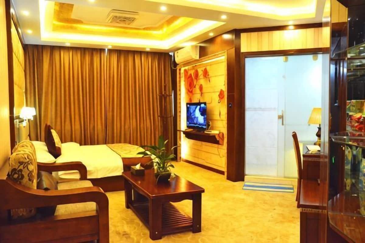 Een hotelkamer met een bed, een televisie, een bureau en een stoel.
