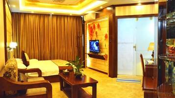 Una habitación de hotel con cama, televisor, escritorio y silla.