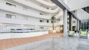 A spacious atrium with multiple floors, a central water feature, and seating areas. - Beachfront 1st Floor | Heated Pool-Sherwin #107 (Daytona Beach Shores)