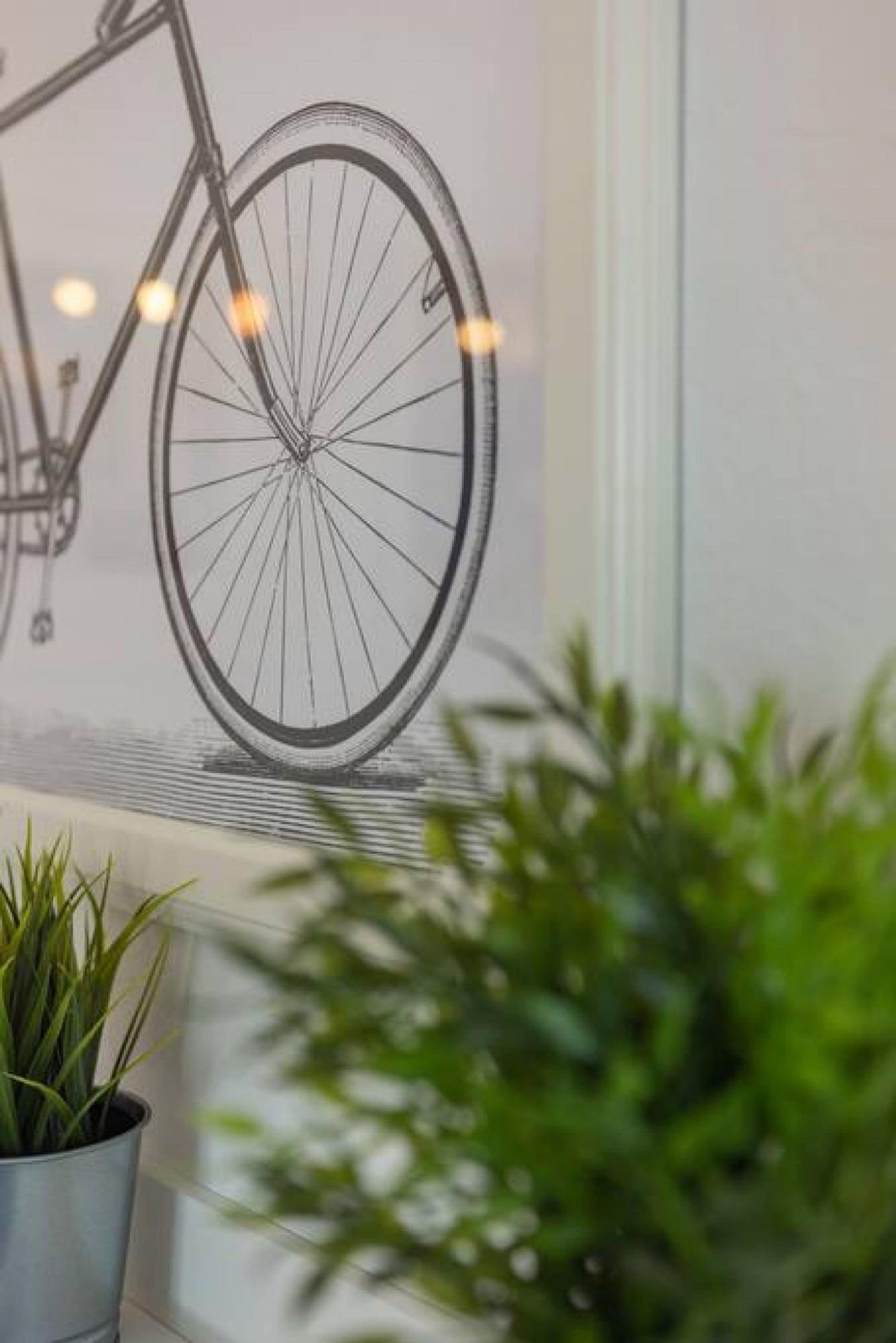 Une illustration en noir et blanc représentant un vélo, encadrée et accrochée au mur.