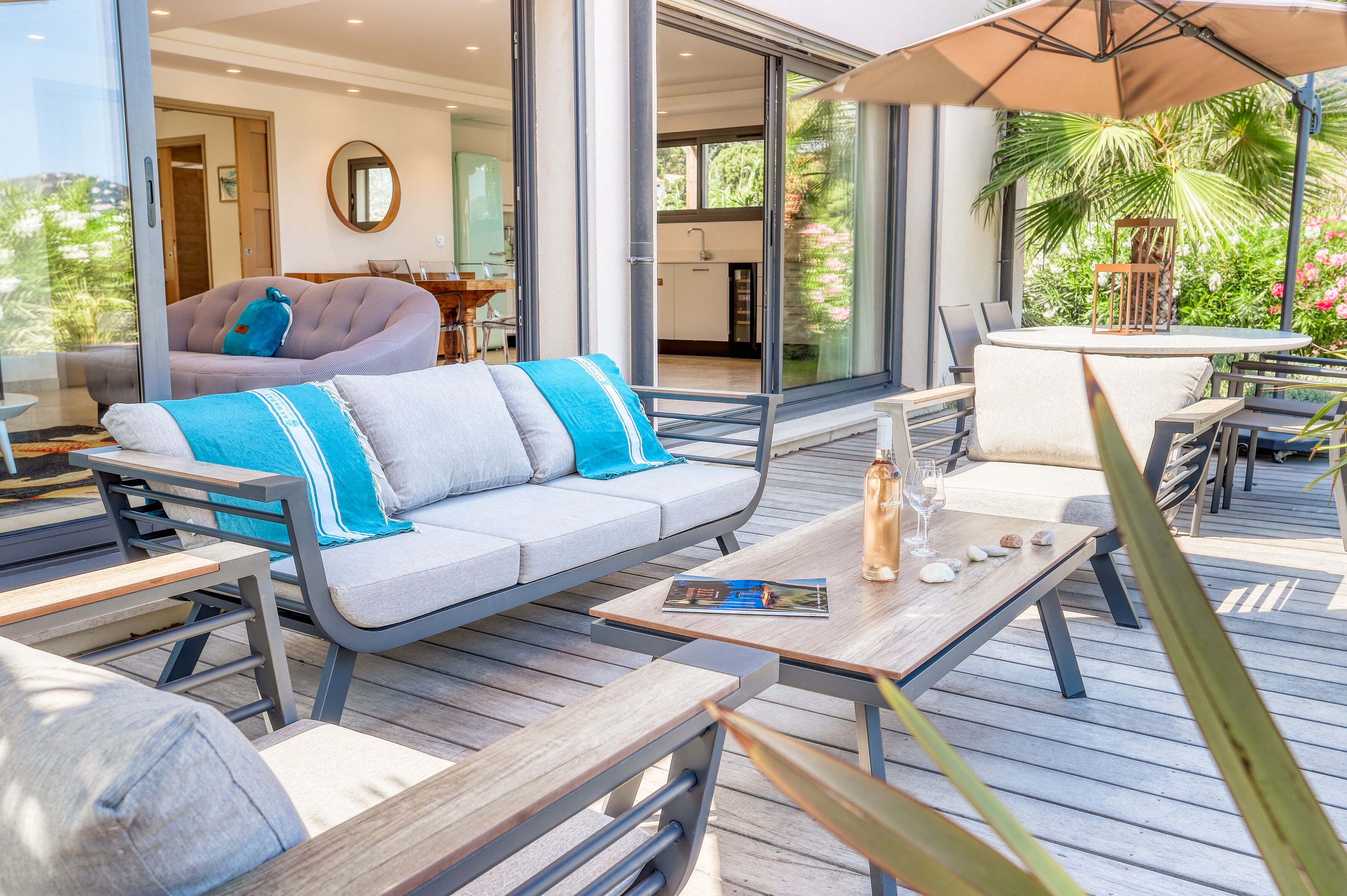A modern outdoor living area with a sofa, dining table, and chairs.