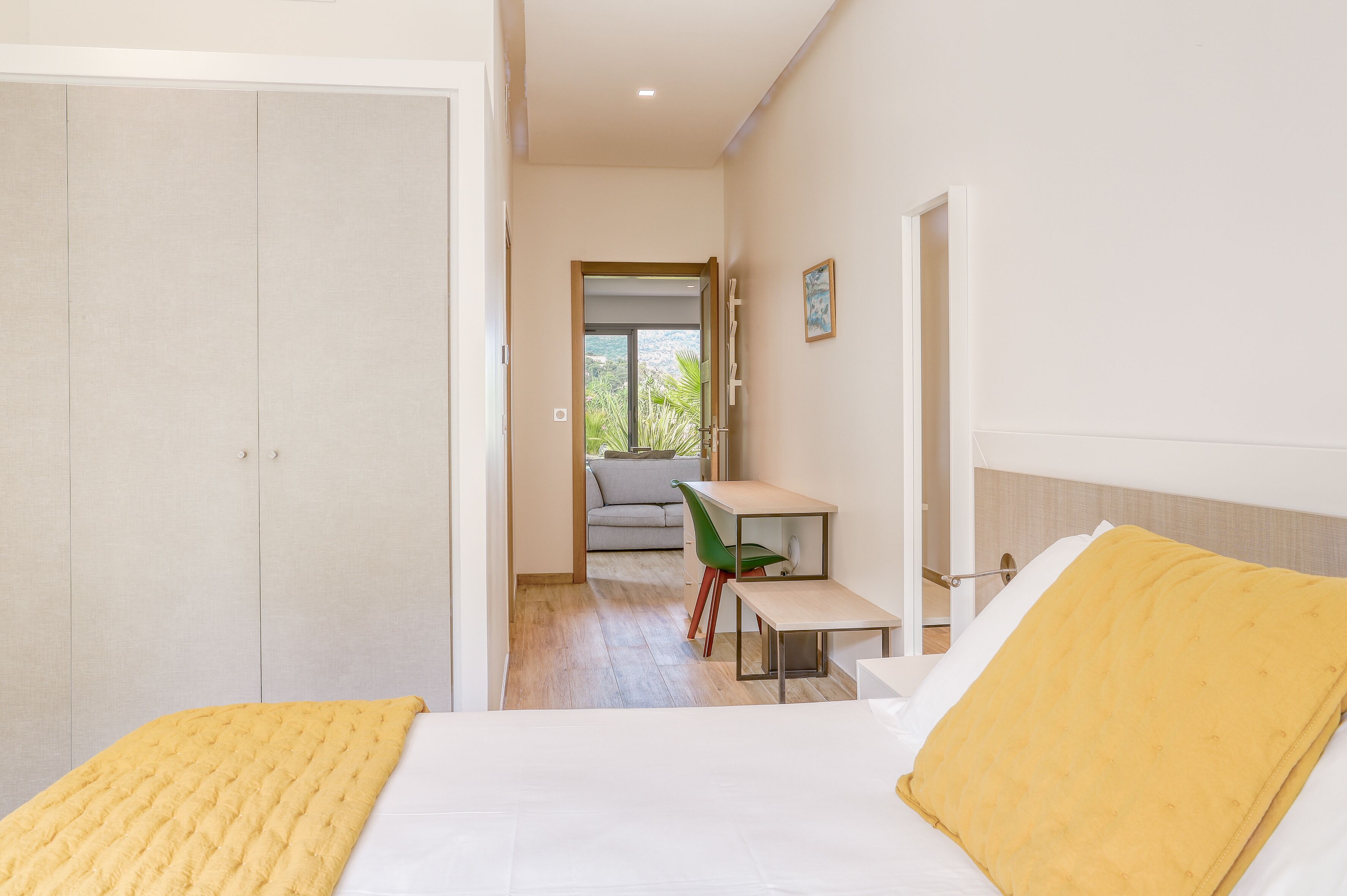 Una habitación de hotel con cama, escritorio, silla y vistas a un balcón.