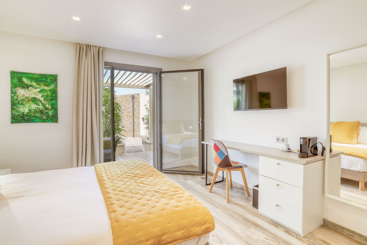 Een moderne hotelkamer met een bed, bureau, stoel en televisie.
