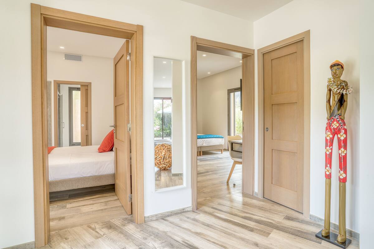 Een hotelkamer met een bed, een raam en een houten deur.