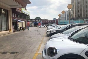 Eine Straße mit parkenden Autos und Gebäuden mit Beschilderung.