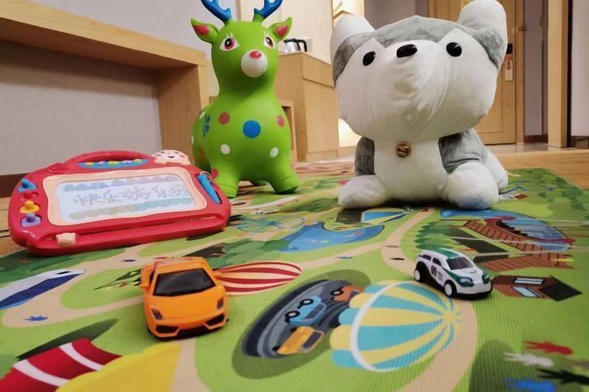 A play mat with toys and a stuffed animal.