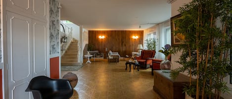 Uma sala de estar ampla com uma parede de madeira, uma escada e uma grande planta em vaso.