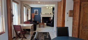 Un área de comedor con una mesa, sillas, un sofá y una chimenea.