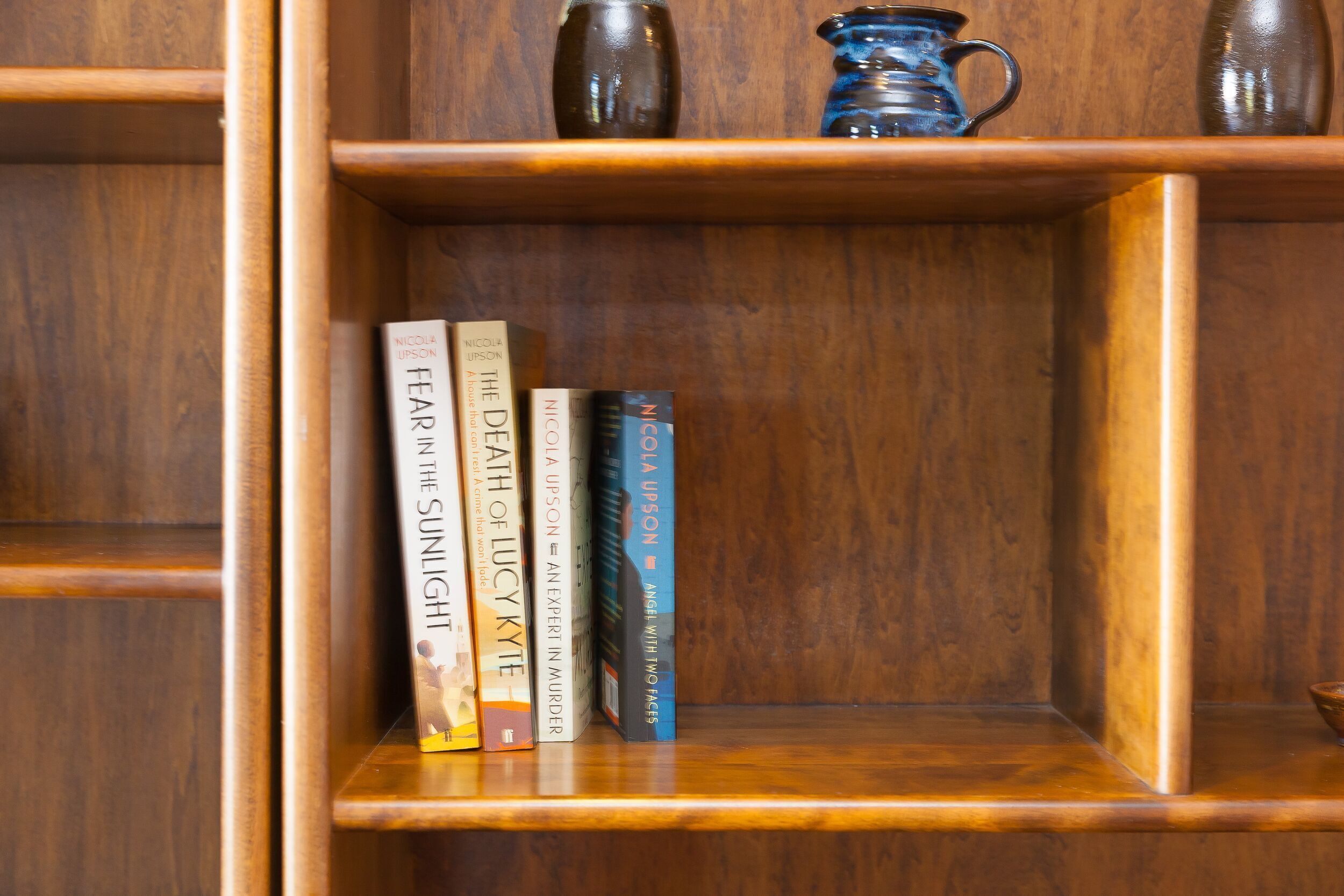 Una estantería de madera con cinco libros de Nicola Lipson.