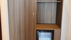 Un armario con un mini refrigerador integrado y un estante.